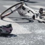 Closeup of kid's helmet and bike on a pedestrian lines after danger incident with a car | TechSplicit Closeup of kid's helmet and bike on a pedestrian lines after danger incident with a car