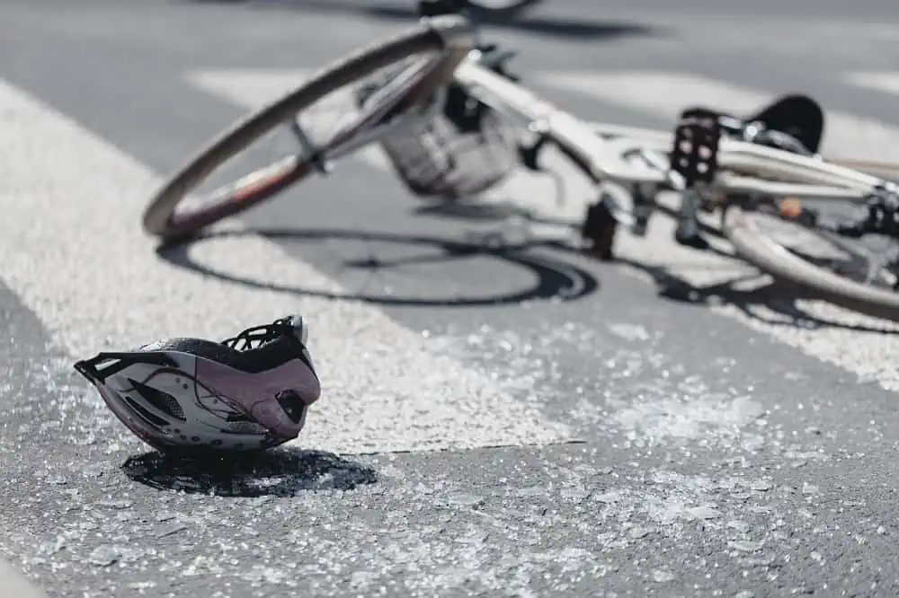Closeup of kid's helmet and bike on a pedestrian lines after danger incident with a car | TechSplicit Closeup of kid's helmet and bike on a pedestrian lines after danger incident with a car