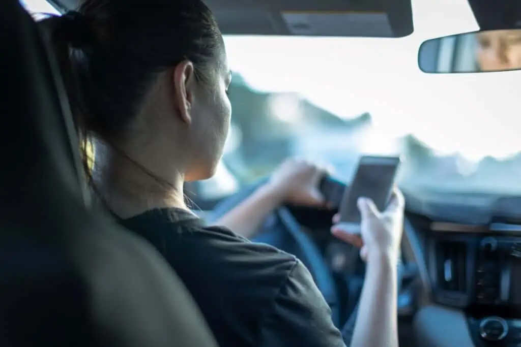 Driver is uing her phone, not payint attention to roads
