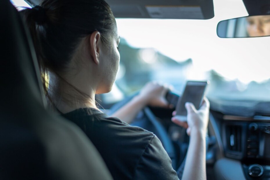 Driver is uing her phone, not payint attention to roads