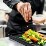 AChefsHandGarnishingAColorfulSaladOnAPlate | TechSplicit What’s Cooking at OYR (and at my house)